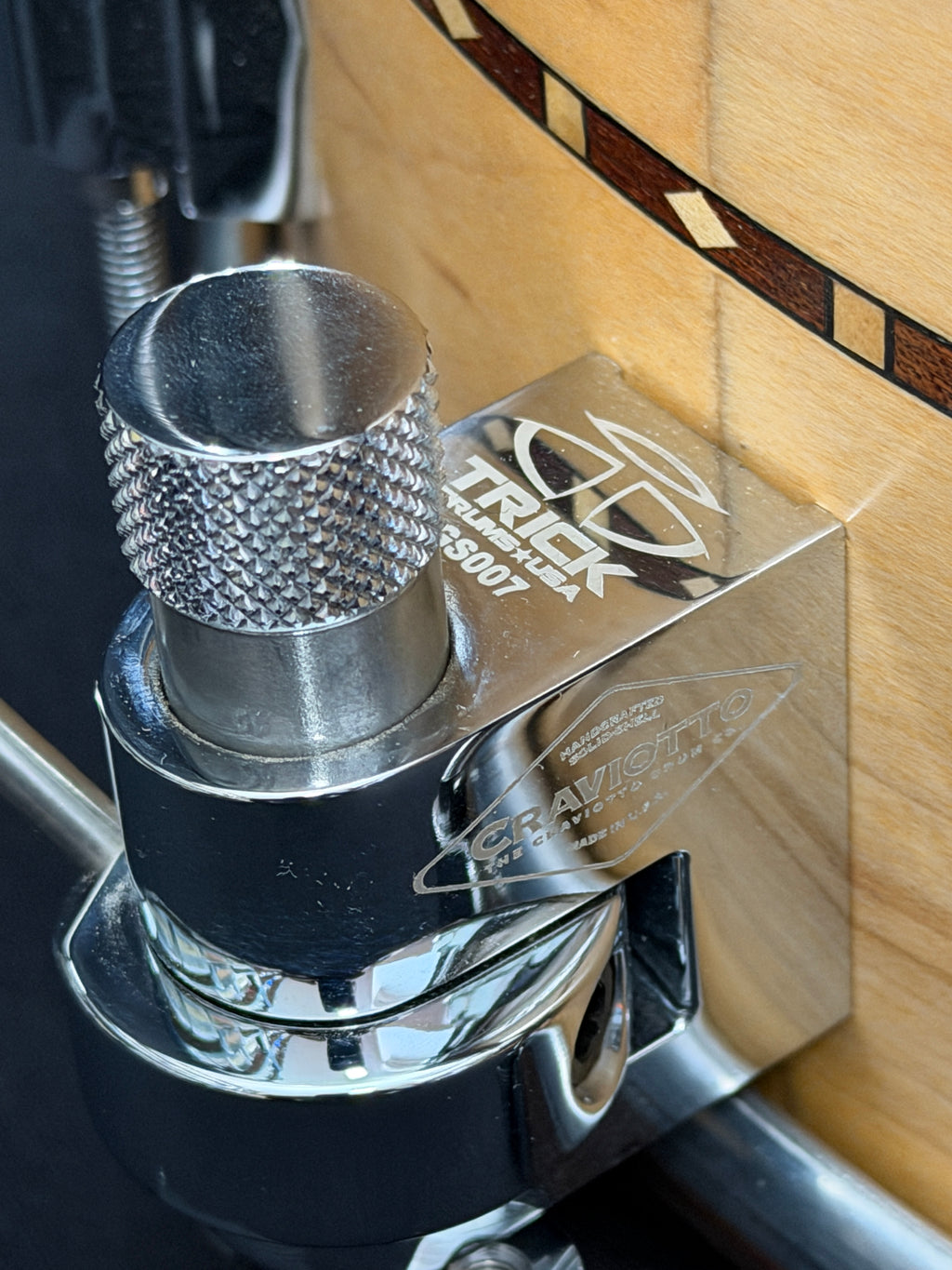 Close-up of a metal knob on a wooden surface with 'Truxedo' branding.